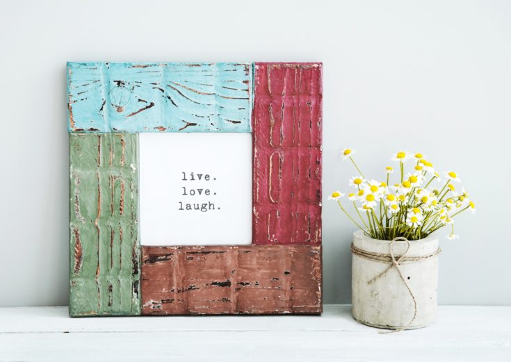 colored red, gree, blue frame LIVE, LOVE, LAUGH with chamomile in diy concrete pot. Skandinavian style room interior