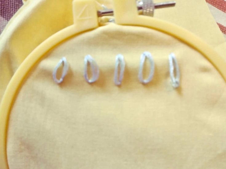 detached chain stitch embroidery example in a yellow cloth