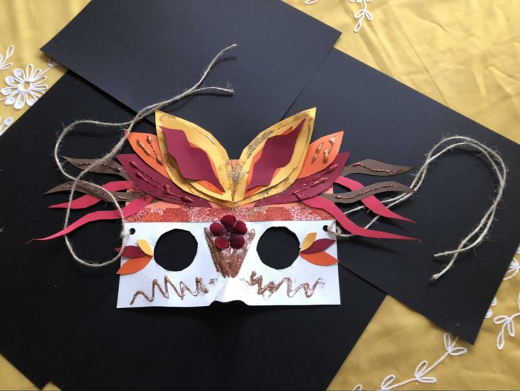 finished bird mask with black colored paper and colorful headdress