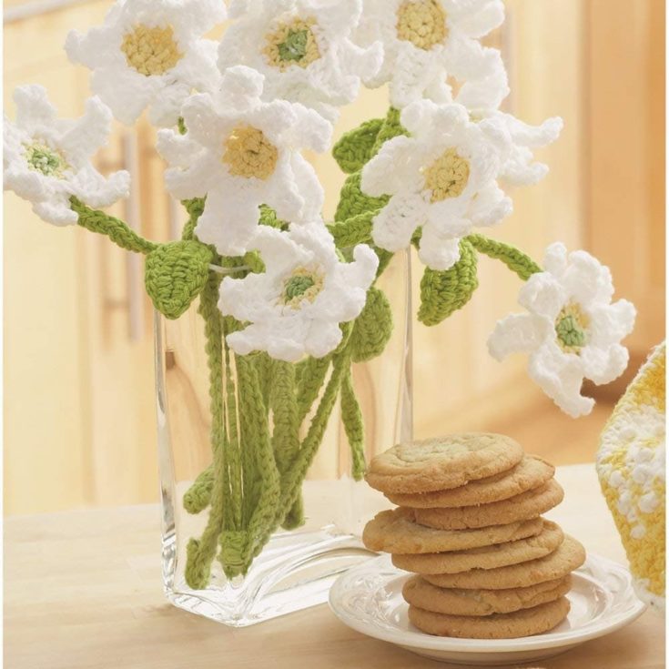 flower yarn in a vase with cookies on the side