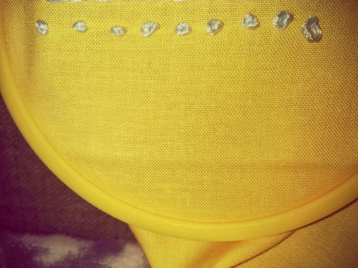 french knot stitch embroidery example in a yellow cloth