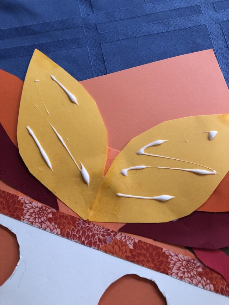 glue on the yellow feather cutout colored paper