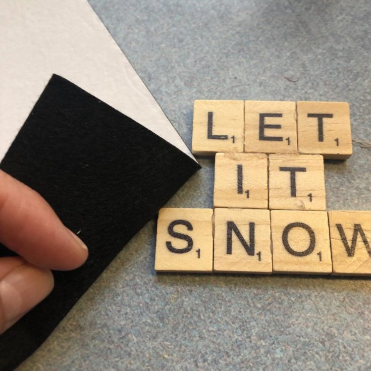 Closed up shot of scrabble letter glued and form into LET IT SNOW words.