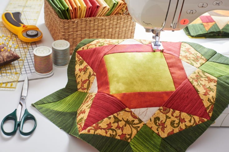 Patchwork orange-green block, quilting fabrics, sewing accessories, with a sewing machine for quilting