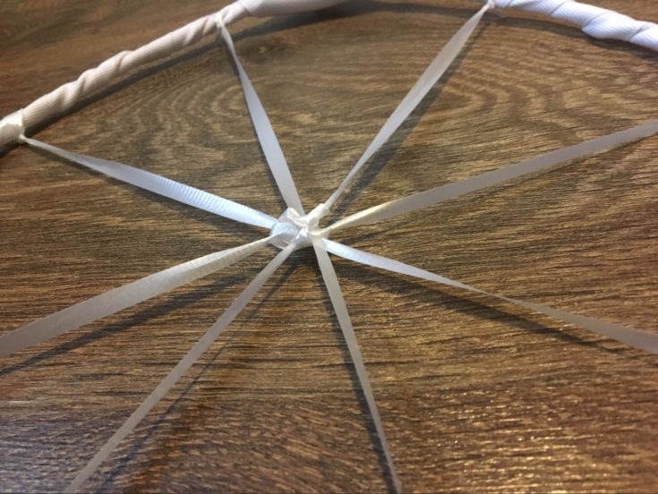 spokes of web using a white ribbon tied at the center