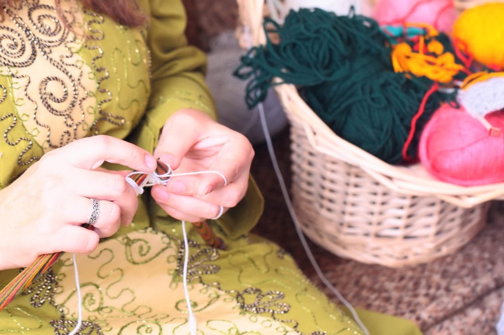 Close-up of woman hands knitting with stylish knitting needles